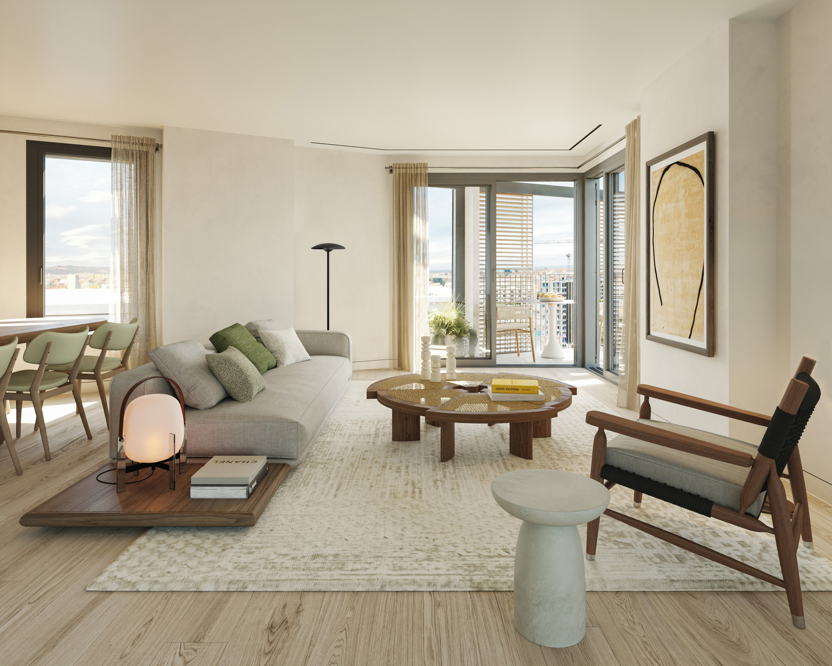 Open-plan living room with a stone kitchen island, a light grey sofa and a round stone coffee table, with the Torre Glòries visible through the terrace doors.